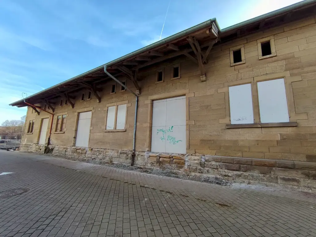 Ein altes Lagerhaus aus glatten Sandsteinblöclen. Die Türen und großen Fenster sind mit weißen Platten abgedeckt